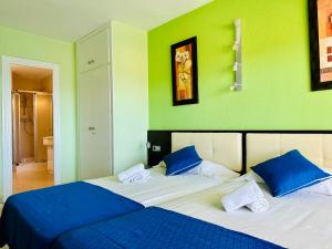 a bedroom with two beds with blue and green walls at BOOK RITS SALOU in Salou