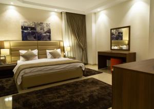 a hotel room with a bed and a desk and a bed sidx sidx at Diamond Land Hotel in Madinat Al Ashir min Ramadan