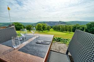 uma mesa de madeira com copos de vinho em cima em Le logis des Chênes, superbe bungalow dans quartier résidentiel proche de Namur em Wépion