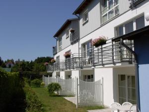 a white house with a white fence and chairs at Ferienwohnung 110 im Haus Katharina mit großer Dachterrrasse in Lauterbach