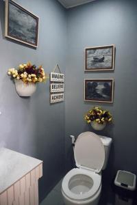 a bathroom with a toilet and flowers on the wall at Cebu Backpackers Hostel in Cebu City