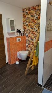 baño con aseo y mural de aves en Ferienhaus Rehblick - direkt in der Natur, mit Lesezimmer und zwei Terrassen en Friedrichroda