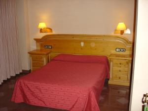 a bedroom with a red bed and two night stands at Hotel Vista Nevada in Darro