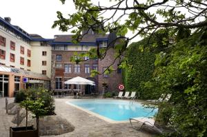 a swimming pool in front of a building at Novotel Gent Centrum in Ghent