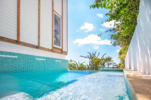 a swimming pool in front of a house with waterfalls at Wow! Views and more, fantastic 2 bedroom in West End - Villa Agua apts in Roatán