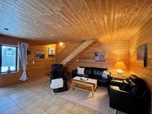 una sala de estar con muebles de cuero y techo de madera. en JS Feriendomizile Haus Abendrot Bettwäsche Handtücher inkl, en Hasselfelde