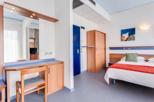 een slaapkamer met een bed en een bureau in een kamer bij El Cid Campeador in Rimini