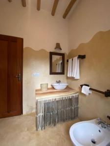 a bathroom with a sink and a mirror at Tembo House - Rafiki Village in Watamu
