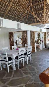 una sala da pranzo con tavolo e sedie in legno di Tembo House - Rafiki Village a Watamu