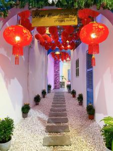 a hallway with red lanterns on a white building at Happy House Homestay in Hue