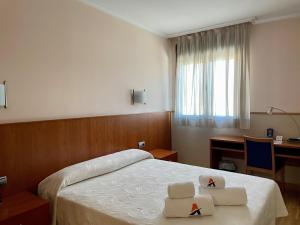 a hotel room with a bed and a desk and a window at Andamur San Román in San Román