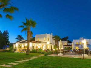 a house with a palm tree in front of it at Bitez Kassandra Hotel in Bitez