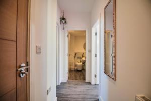 - un couloir avec une salle de bains pourvue de toilettes et d'un miroir dans l'établissement York Crescent Apartments, à York