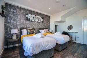 a bedroom with two beds and a wall at York Crescent Apartments in York