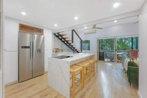 a kitchen with a sink and a counter with a refrigerator at On the Brook - Private 2 bed + loft and pool in Brisbane