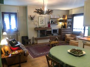 een woonkamer met een bank en een tafel bij Splendido trilocale direttamente sulle piste in Aprica
