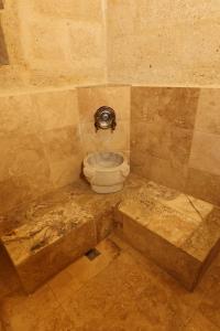 Zanta Suite Hotel في أوروغوب: حمام مزين بالبلاط مع مرحاض في الزاوية