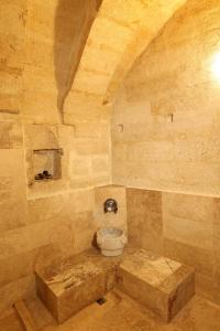 Zanta Suite Hotel في أوروغوب: حمام حجري مع مرحاض في الغرفة