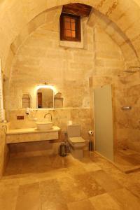 a stone bathroom with a sink and a toilet at Zanta Suite Hotel in Urgup