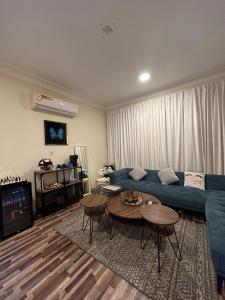 uma sala de estar com um sofá azul e uma mesa em شقه بغرفة نوم تسجيل دخول ذاتي em Ar Rākah