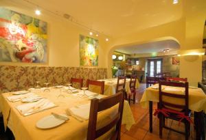 een eetkamer met tafels met witte tafelkleden bij Hotel Rural Quinta da Geia in Aldeia das Dez