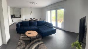 a living room with a blue couch and a table at Apartmani Lana in Rab