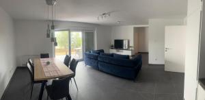 a living room with a blue couch and a table at Apartmani Lana in Rab