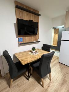 a kitchen with a wooden table and black chairs at Apartman Antonovic in Valjevo +19 photos