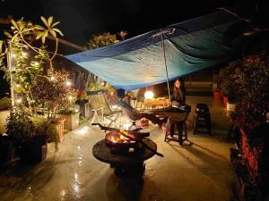a woman sitting at a table under an umbrella at Sun Moment 鬆貓們民宿 in Toucheng