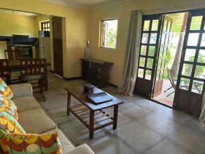 a living room with a couch and a coffee table at Garden Beach Apartment Zanzibar in Pwani Mchangani