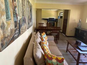 a living room with a couch and a table at Garden Beach Apartment Zanzibar in Pwani Mchangani