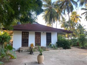 a small house with a vase in front of it at Garden Beach Apartment Zanzibar in Pwani Mchangani