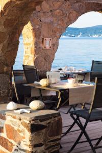 a restaurant with tables and chairs and the water at La Belle Aurore - Les Collectionneurs in Sainte-Maxime