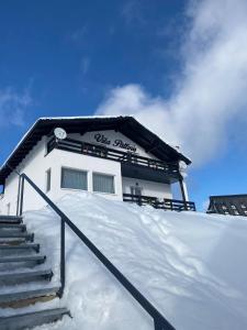 um edifício no topo de uma encosta coberta de neve em Vila Paltinis em Păltiniş