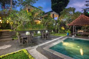 a house with a swimming pool and a table and chairs at Alas Petulu Villa Resort and Spa in Ubud