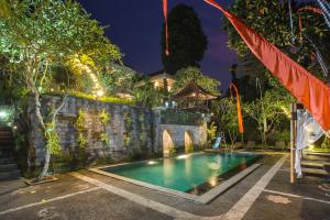 a swimming pool in front of a house at night at Alas Petulu Villa Resort and Spa in Ubud
