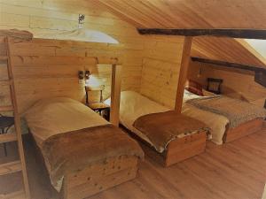 1 dormitorio con 2 camas en una cabaña de madera en L'Ours Blanc en La Féclaz