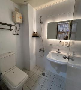 a white bathroom with a toilet and a sink at 逢甲美學院 in Taichung