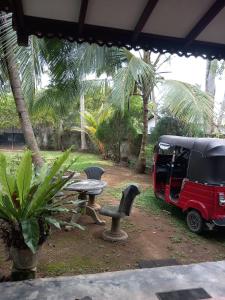 uma mesa e cadeiras ao lado de uma carrinha estacionada em The Madampa Village Side Lodge em Ambalangoda