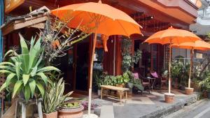 dos sombrillas naranjas frente a un edificio en The North Hotel, en Chiang Rai