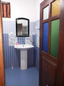 ein Bad mit einem Waschbecken und einem Spiegel in der Unterkunft The Madampa Village Side Lodge in Ambalangoda