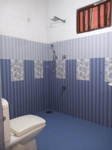 uma casa de banho azul com um chuveiro e um WC em The Madampa Village Side Lodge em Ambalangoda