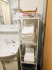 a bathroom with a sink and a rack with towels at Utatei Sou in Takayama