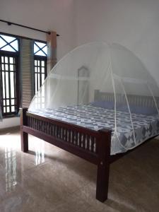 ein großes Bett mit Baldachin in einem Zimmer in der Unterkunft The Madampa Village Side Lodge in Ambalangoda
