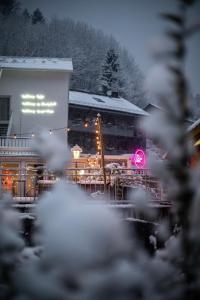 a building with a neon sign in the snow at DAS SCHÖNE LEBEN Pop-Up Hotel in Hornberg