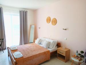 a bedroom with a bed and a large window at Agathi Paradise Studios in Haraki