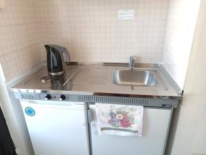 a small kitchen with a sink and a refrigerator at Agathi Paradise Studios in Haraki +33 photos