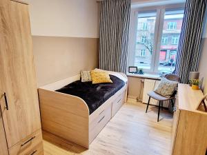 Dormitorio pequeño con cama y ventana en Old Town Room Ełk, en Ełk