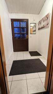 a hallway with a door and a tile floor at Grüne Haus in Vöhl