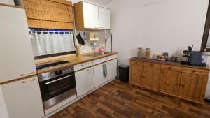 a kitchen with white appliances and wooden cabinets at Grüne Haus in Vöhl